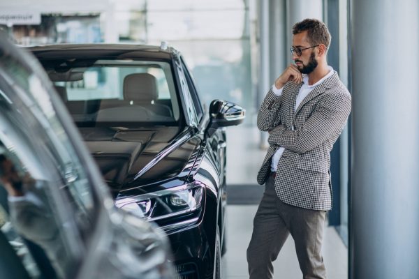 Business man choosing a car in a car showroom